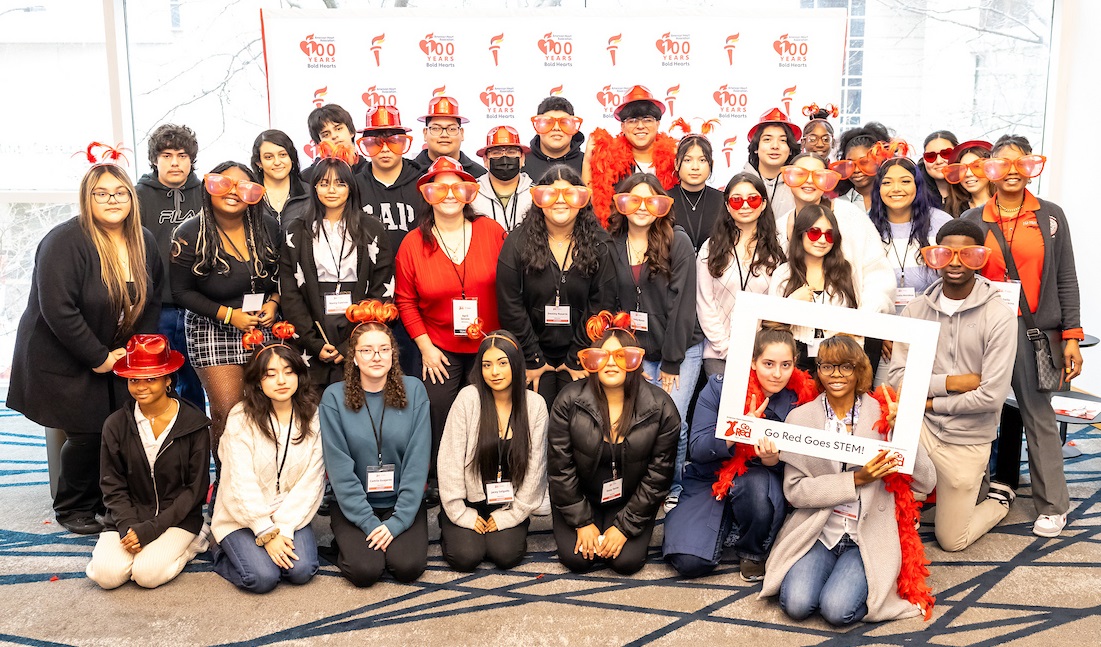 Group photo of STEM attendees in front of American Heart Association one hundred years of bold hearts banner. Group photo of STEM attendees in front of American Heart Association one hundred years of bold hearts banner.